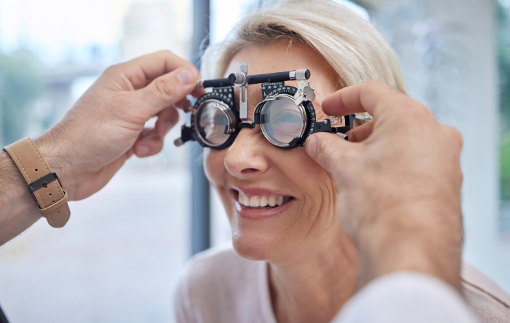 Hands, help or woman in eye exam or vision test for eyesight by doctor, optometrist or ophthalmologist. Optician helping a happy customer to see or check glaucoma or retina health in a consultation.