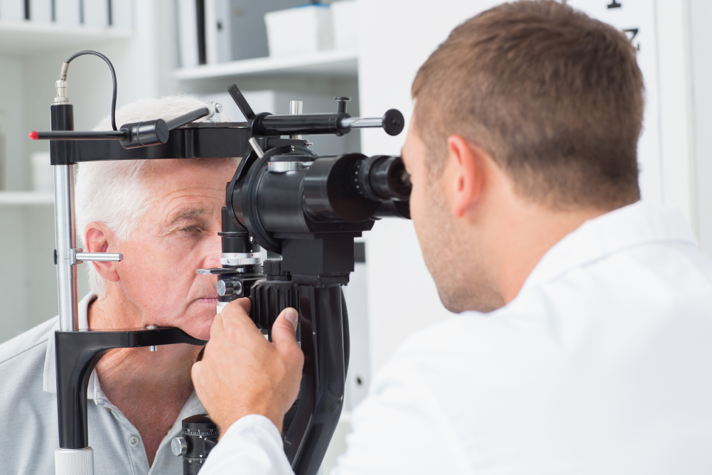 optician examining senior patients eyes